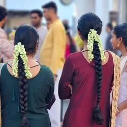 Viele Frauen tragen Blumen im Haar.