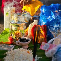 Opfergaben stehen bereit neben den Gläubigen die gerade gepierct werden.