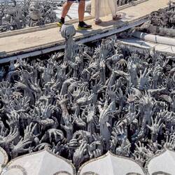 Zu sehen sind Skulpturen von Gefangenen, die ihre Arme emporstrecken, um zu Buddha zu gelangen