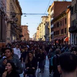 Sea of people on Via Rizzoli on a Saturday afternoon near Due Torri — Bologna, Italy.