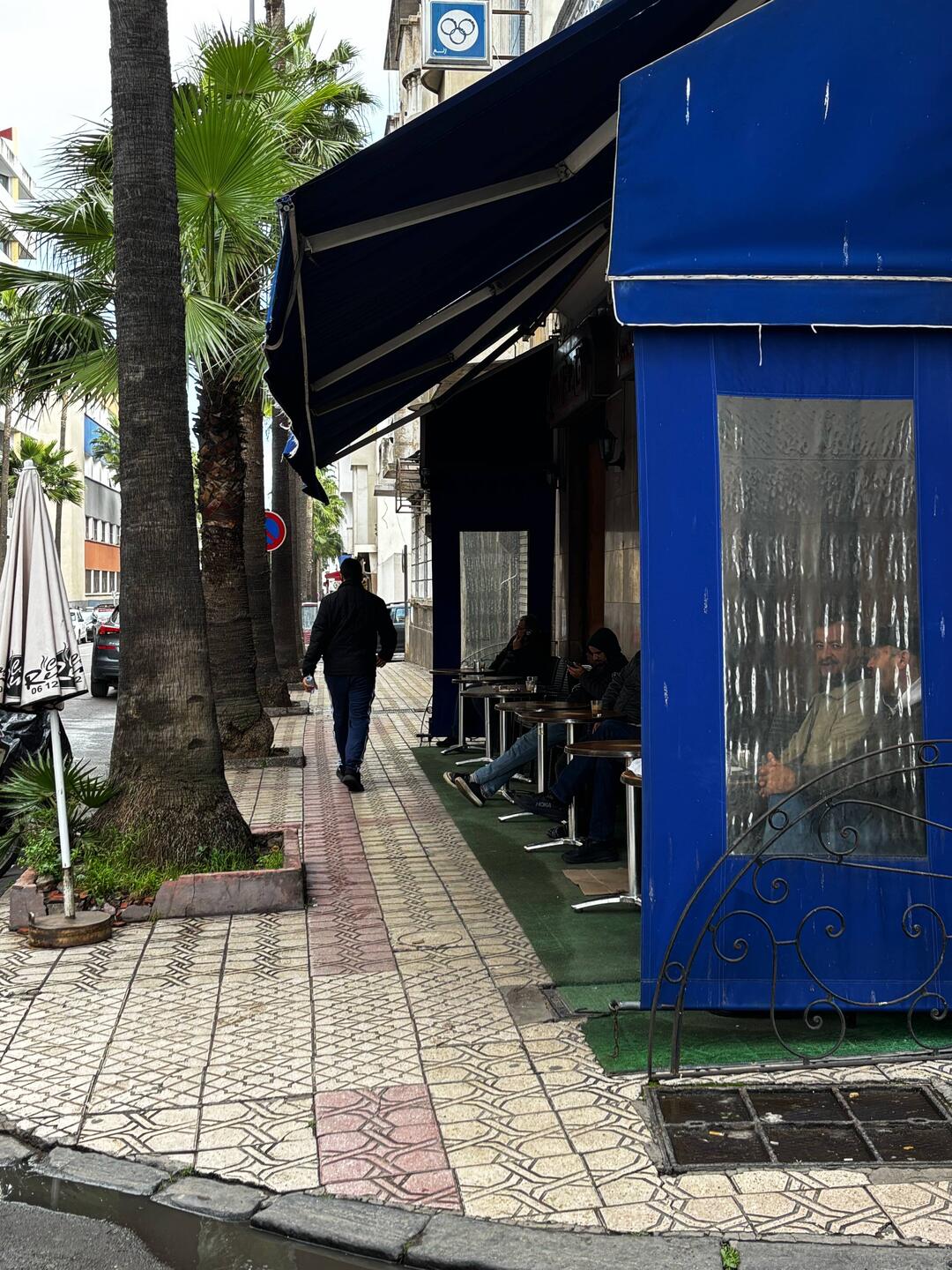 Cafe seats face out and men sit there watching women.