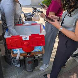 A customer uses her cell phone to scan a QR code attached to the handlebars of the motorbike.