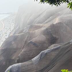 The mountain side is contained with netting