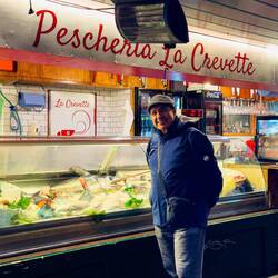 Fish vendor outside the portico at Piazza Aldrovandi — Bologna, Italy.