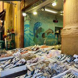 Mui finds a fishmonger; I find a mosaic mural — Bologna, Italy.