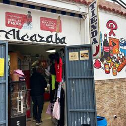 Wildgemischter Bazar, wo Zahnpasta, Puppen und Dekosachen im selben Glasregal aufgestapelt sind.
