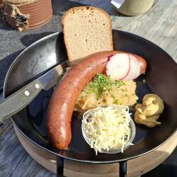Hauswurst mit Sauerkraut, Kren und Almbrot.