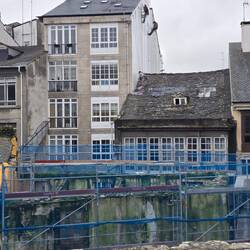Men suspended painting with repelling ropes.