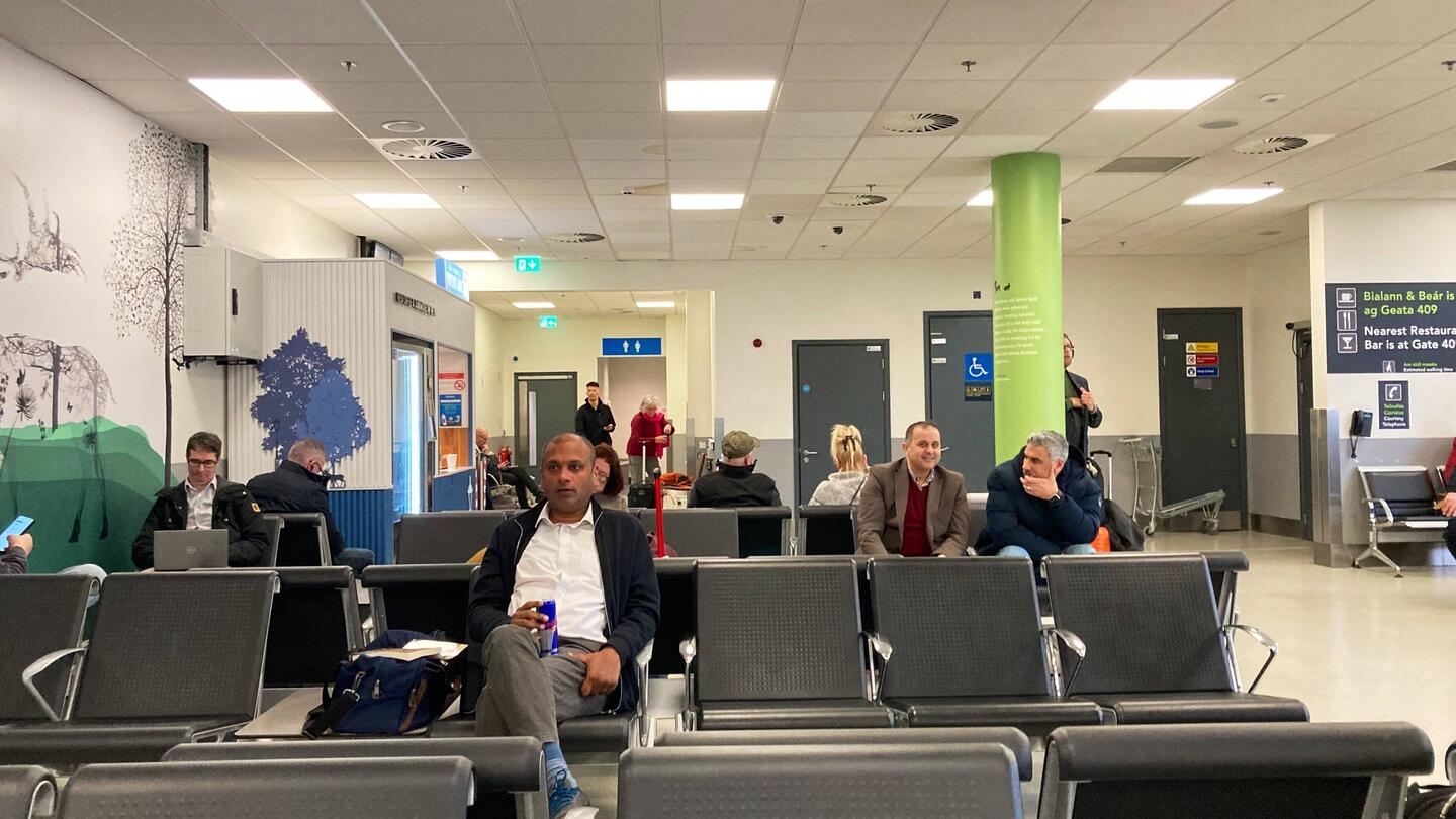 A distant Beverly gets water in the spartan waiting area