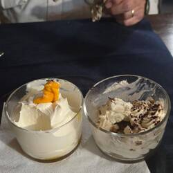 Two desserts half eaten. Tiramisu and Mango Mousse.