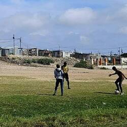 Spielende Kinder an der Autobahn vor ihrem Township