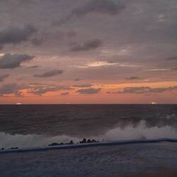 Sunset, large waves, and 2 departing cruise ships