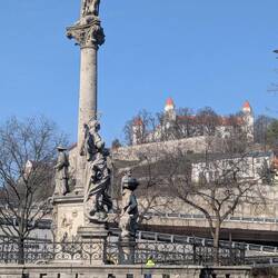 Looking toward castle on the hill with plague memorial in foreground