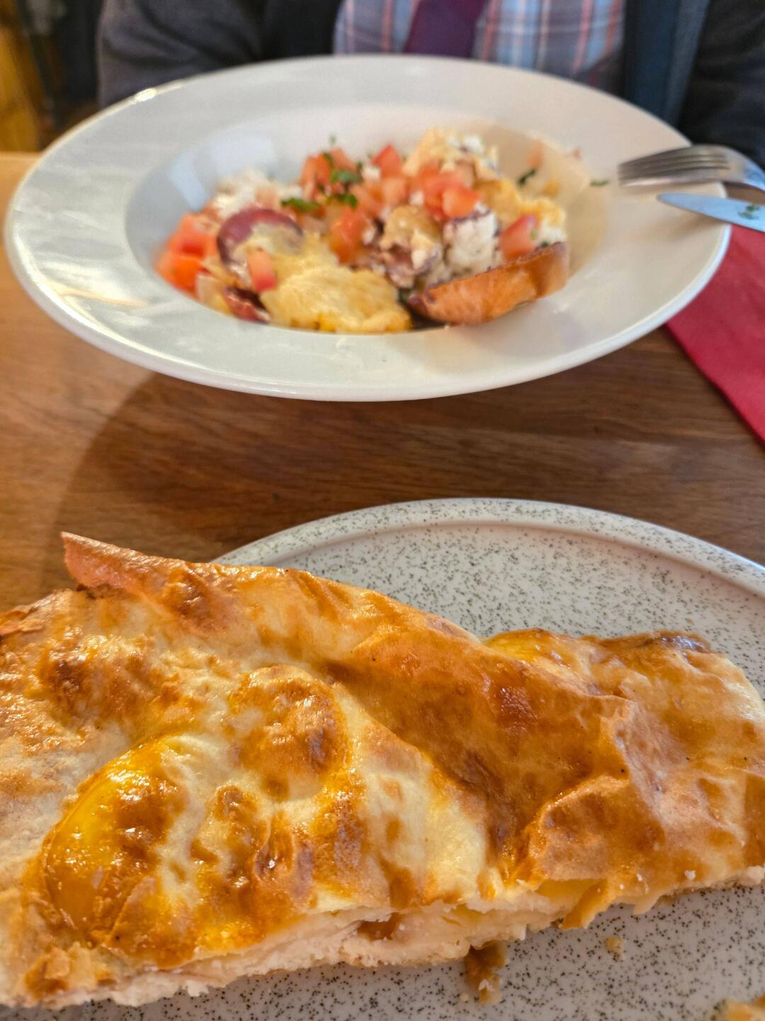 Breakfast of Banitsa pastry and scrambled eggs with sausage and goat cheese