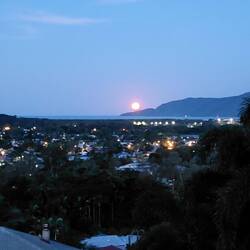 The full moon rising over the Coral Sea with Cairns city in the foreground