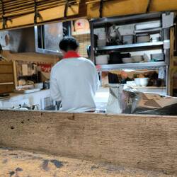 El cocinero esta en el medio de un cuadrado y los clientes se sientan alrededor