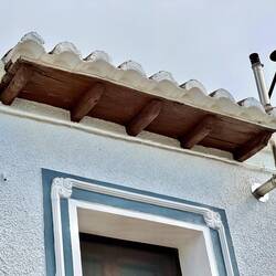 Arabic tile eaves over a wooden corbel