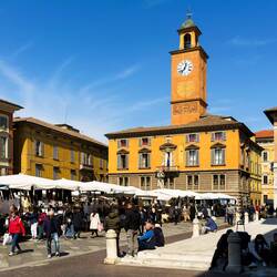 Market in Piazza Prampolini and the clock tower at Palazzo Monte di Pietá — Reggio Emilia, Italy.