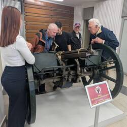 The old men gun nerds around the Civil War-era gatling gun.