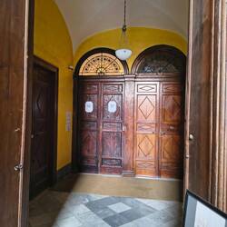 Hoteleingang, daneben eine Wohnung, es leben auch Privatleute im Palazzo, und es gibt Arztpraxen