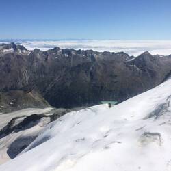 Hinter der Bergkette liegt Italien unter dichten Wolken