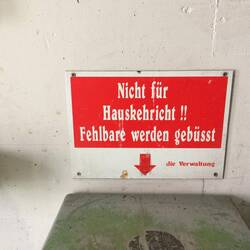Schild über einem Mülleimer im Parkhaus. Bei den vielen Kirchen muss es wohl viele Büße geben.