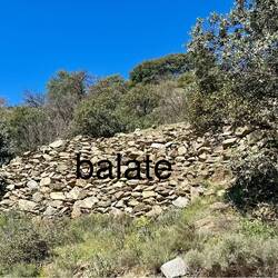 A balate is a dry stone wall used to support the outer edge of a bancal.