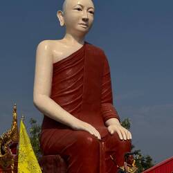 Large peaceful monk watches over the road.
