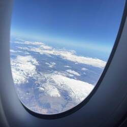 CX292 flew over some snowy mountains. I wondered if we flew over my cousin's farm.