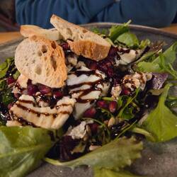 Salad of greens, grilled sheep cheese, fresh pomegranates, and walnuts.