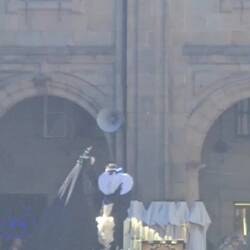 A child dressed as an angel removes the shroud of grief.