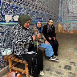 und Frauen die an den touristischen Orten Strümpfe stricken und verkaufen