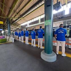 Wenn der Zug ausfährt, steht das Bahnhofspersonal Spalier