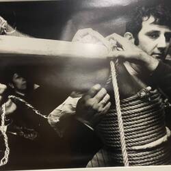 Der Pfahl wird an den Armen festgebunden.