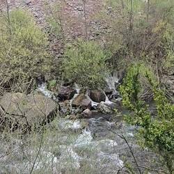 Water flowing into the river from the mountain and view of the mill race covered walkway
