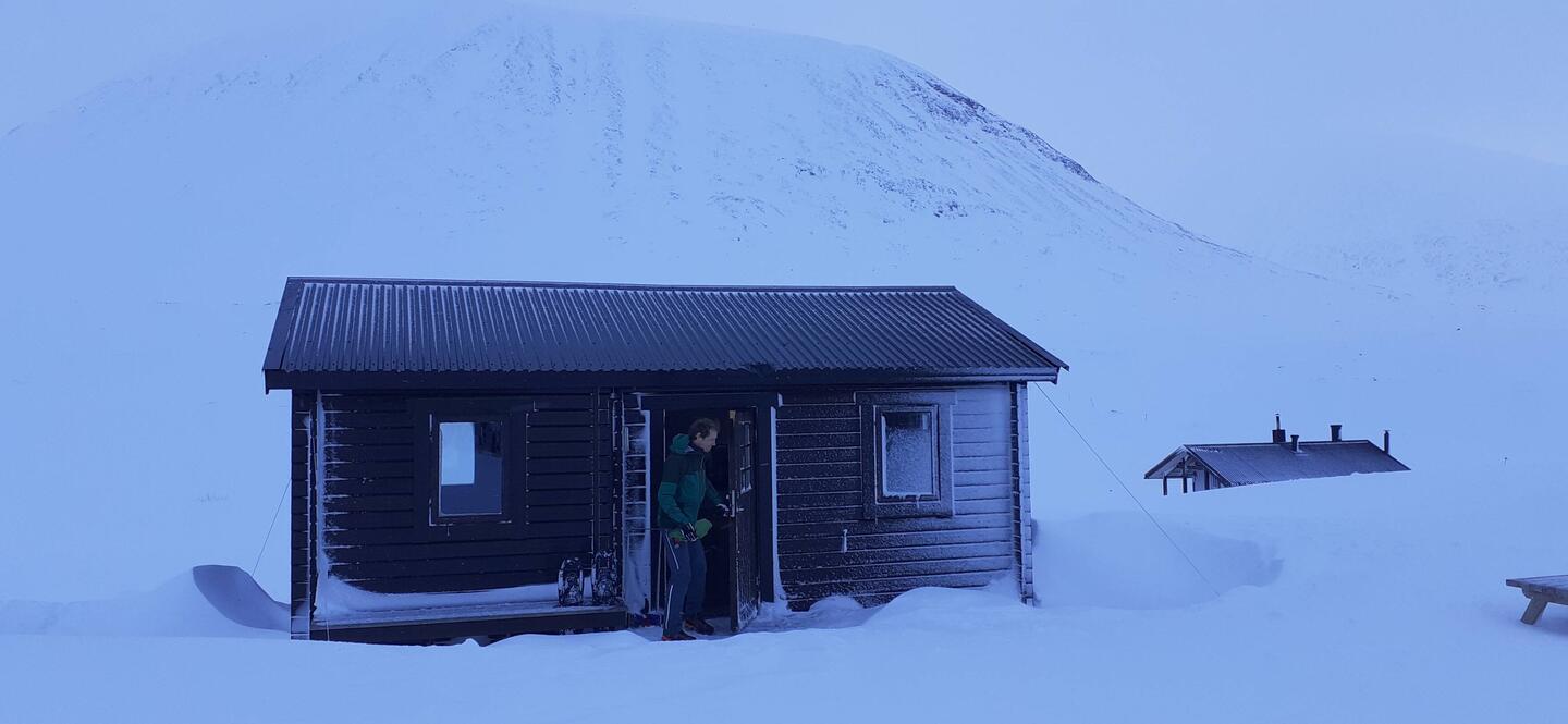 der Camper kommt vom Frühstück aus einer Schutzhütte. neuer Tag - der übliche Sturm