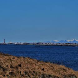 Andenes mit Senja im Hintergrund und dem Leuchtturm an der Spitze