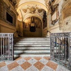 Leading to the grand staircase of the Legisti is a monument to Cardinal Carlo Borromeo.
