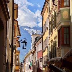 durch die Laubengänge mit Blick auf schneebedeckte Gipfel