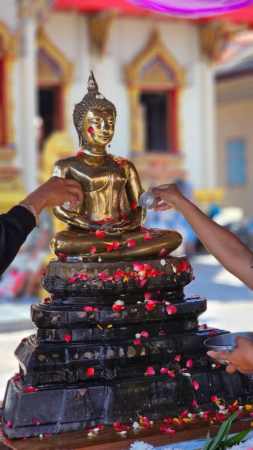Buddhastatue mit Wasser übergießen.