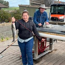 Carmen with her fish, Steve helping to clean them.