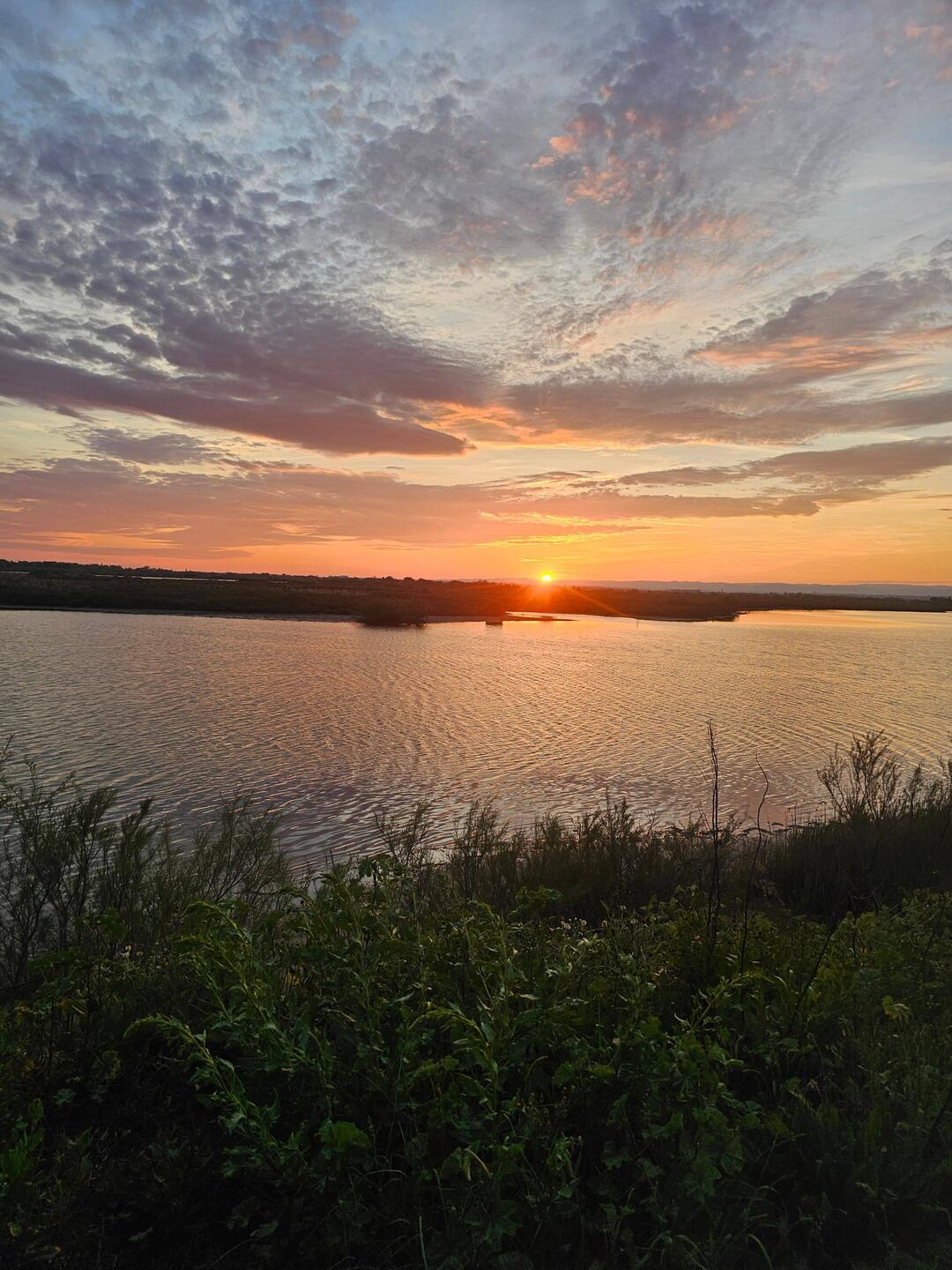Sonnenuntergang über einem See neben dem Stellplatz
