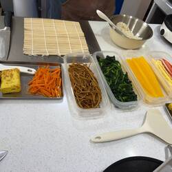 Die langen braunen "Fäden" sind die eingelegten Wurzeln der Grossen Klette fürs Kimbap.
