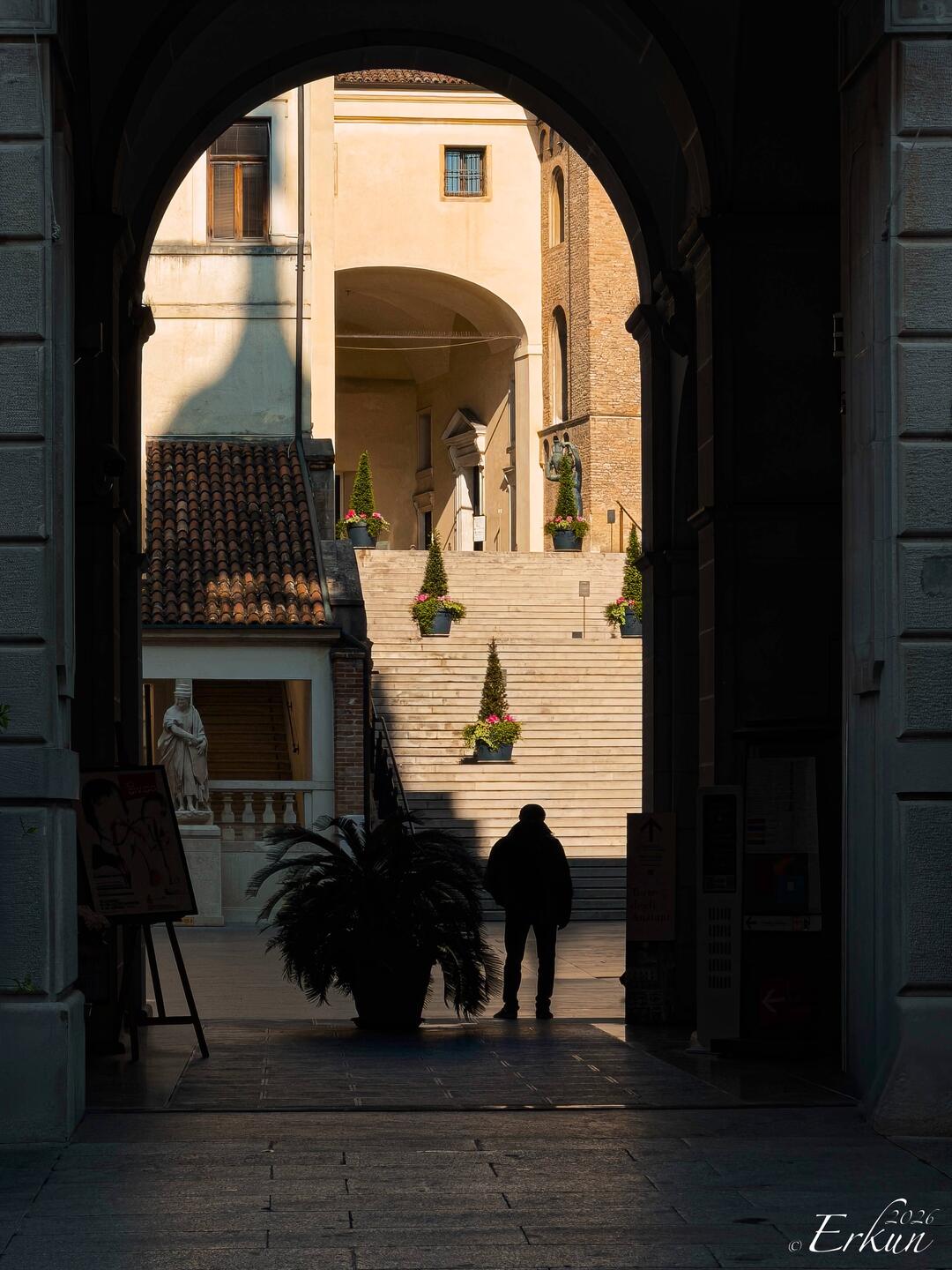 Peeking through the arched entry into the lower courtyard of Palazzo Moroni — Padova, Italy.