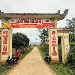 A gate to a village written with socialist slogans on its pillars