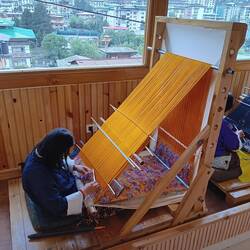 Woman weaving a very intricate pattern.  A table runner cost $3800 US