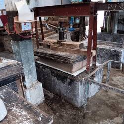 A press to squeeze excess water out of the paper layers
