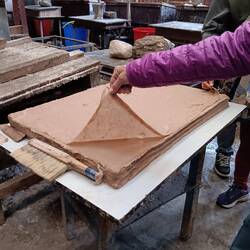 Lifting a corner of a sheet of undried paper