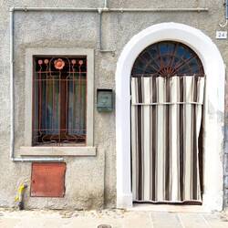 Shade curtain in the doorway ... we saw a lot of these all around town — Comacchio, Italy