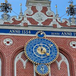 Das Zifferblatt am Schwarzhäupterhaus zeigt eine historische Uhr an der Fassade am Rathausplatz.